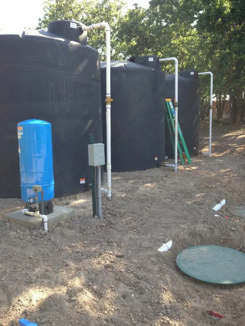 Water storage tanks piped to a pump and pressure tank