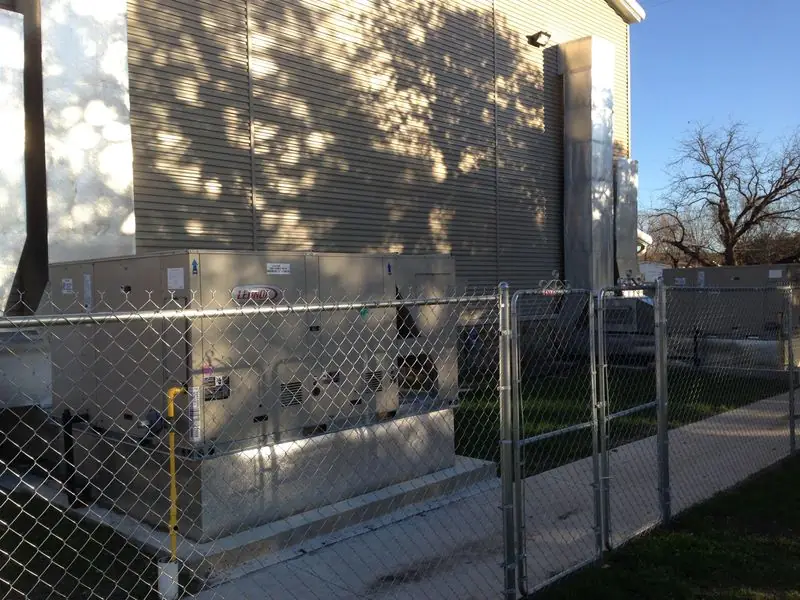 Outdoor HVAC unit in a fenced equipment yard