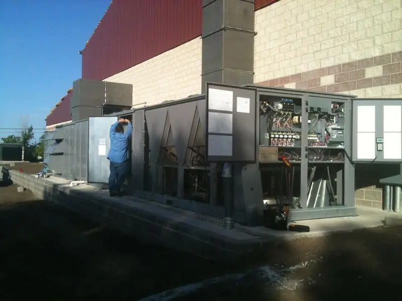 Technician working on a large outdoor HVAC unit
