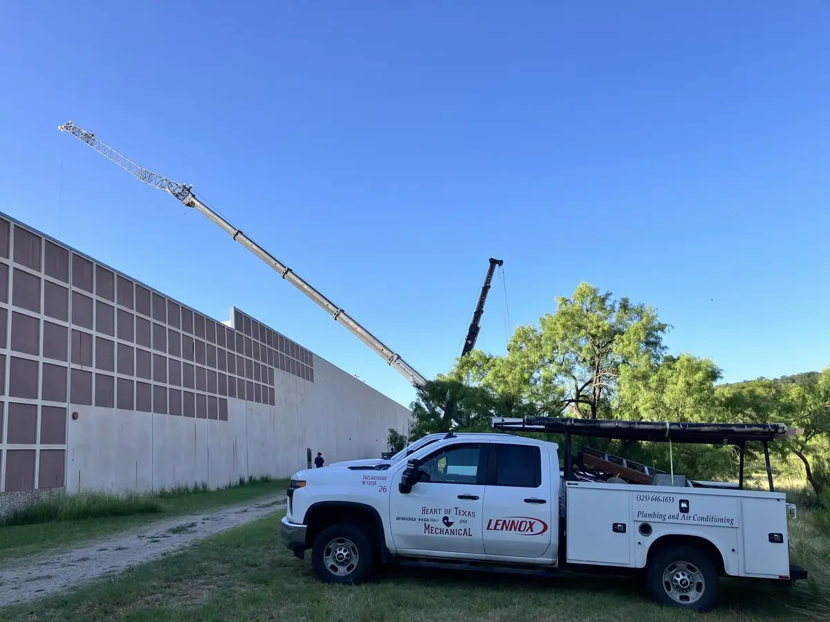 Heart of Texas Mechanical truck beside a crane on a commercial job